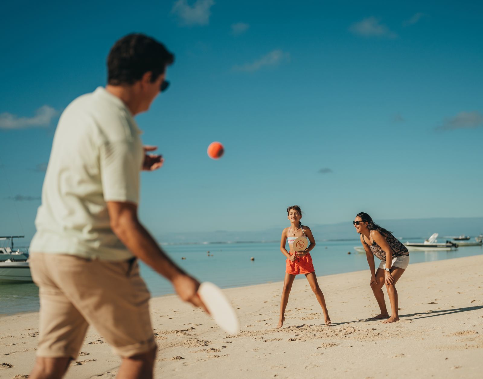 Famille jouant au beach-tennis sur la plage